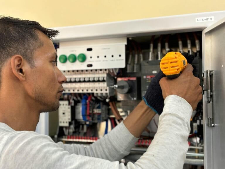 Electrician using a circuit breaker finder to identify the correct breaker in a residential panel