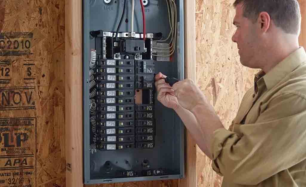 A man is checking the circuit breaker in his home.